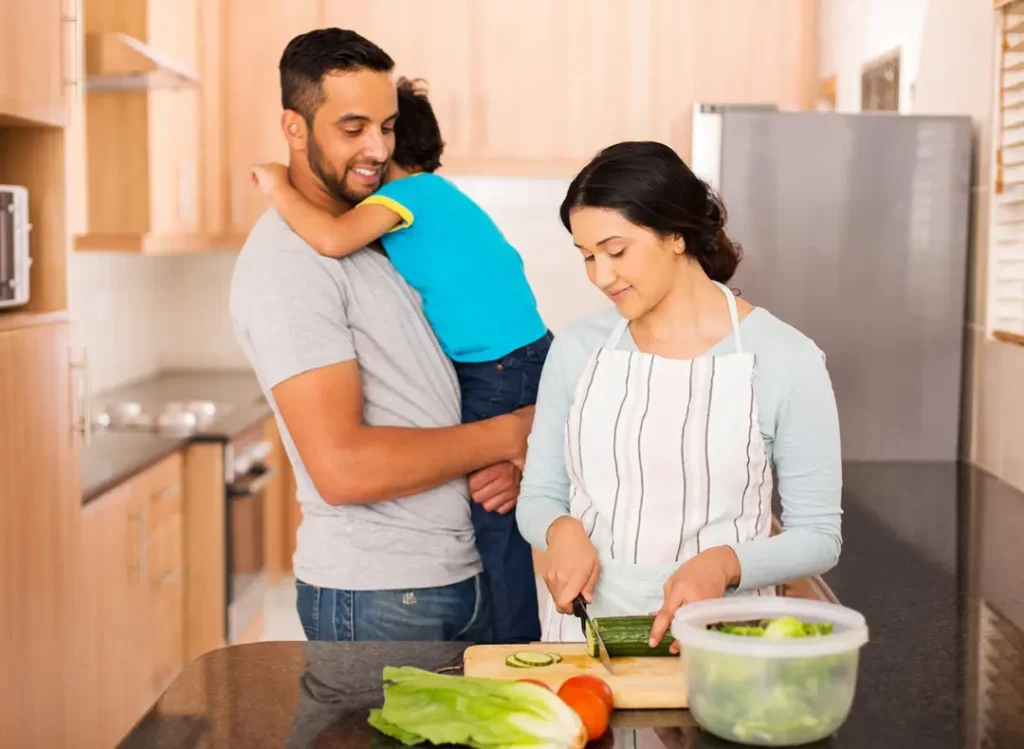 Couple with child chopping vegetables